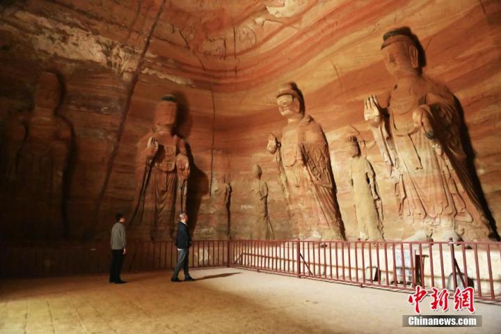 7月15日，游人參觀甘肅省平?jīng)鍪袥艽h百里石窟長(zhǎng)廊中的南石窟寺1號(hào)窟。百里石窟長(zhǎng)廊位于涇川縣境內(nèi)，由512個(gè)石窟、5眼窟中石井組成，現(xiàn)存王母宮石窟、鳳凰山石窟、南石窟寺、丈八寺石窟、羅漢洞石窟、太山寺石窟等規(guī)模較大的石窟群，還有數(shù)量眾多的小石窟群。南石窟寺開(kāi)鑿于北魏永平三年，其中1號(hào)窟屬于大型七佛窟，七佛高達(dá)6米。中新社記者 李亞龍 攝